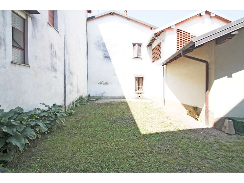 Un'immagine che ritrae parete, architettura, casa, cortile e prato.